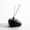 Diffusore a forma di sasso, in legno, colore nero, realizzato a mano dalla Falegnameria Barra Samugheo